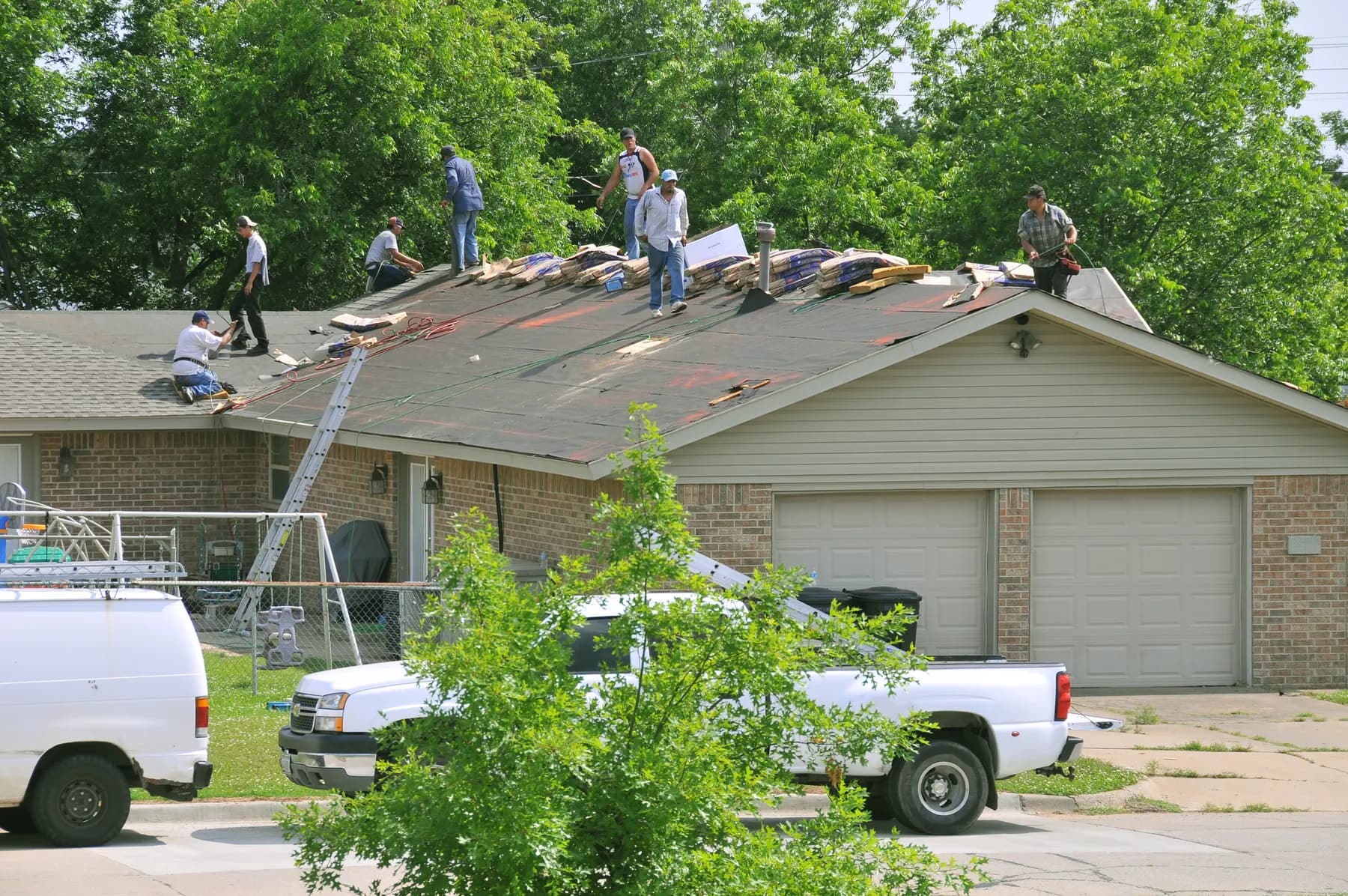 A roofing crew stripping the old shingles off a single story home in Kestrel Point